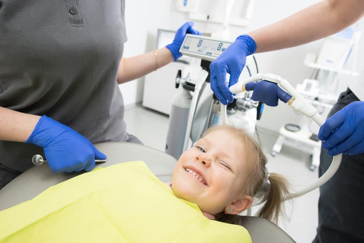 Smiling little girl in dental chair, relaxed and happy during her dental visit