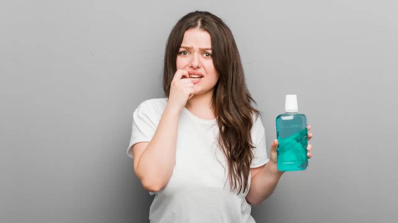 Assortment of oral hygiene products including mouthwash bottles, interdental brushes, and floss on a countertop