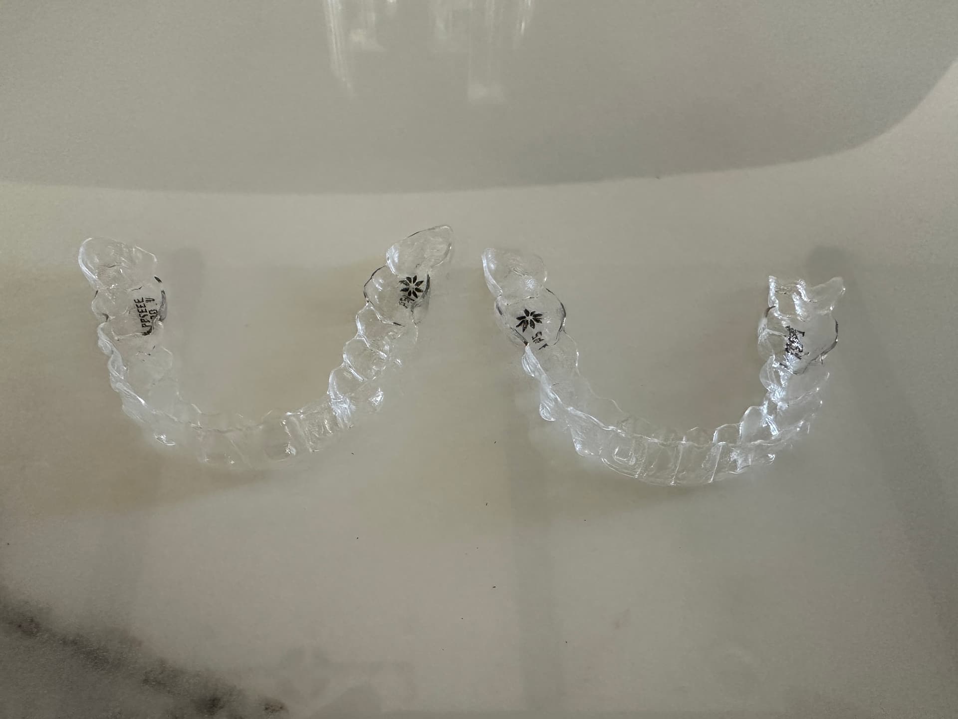 Real Invisalign clear aligner trays on a marble countertop