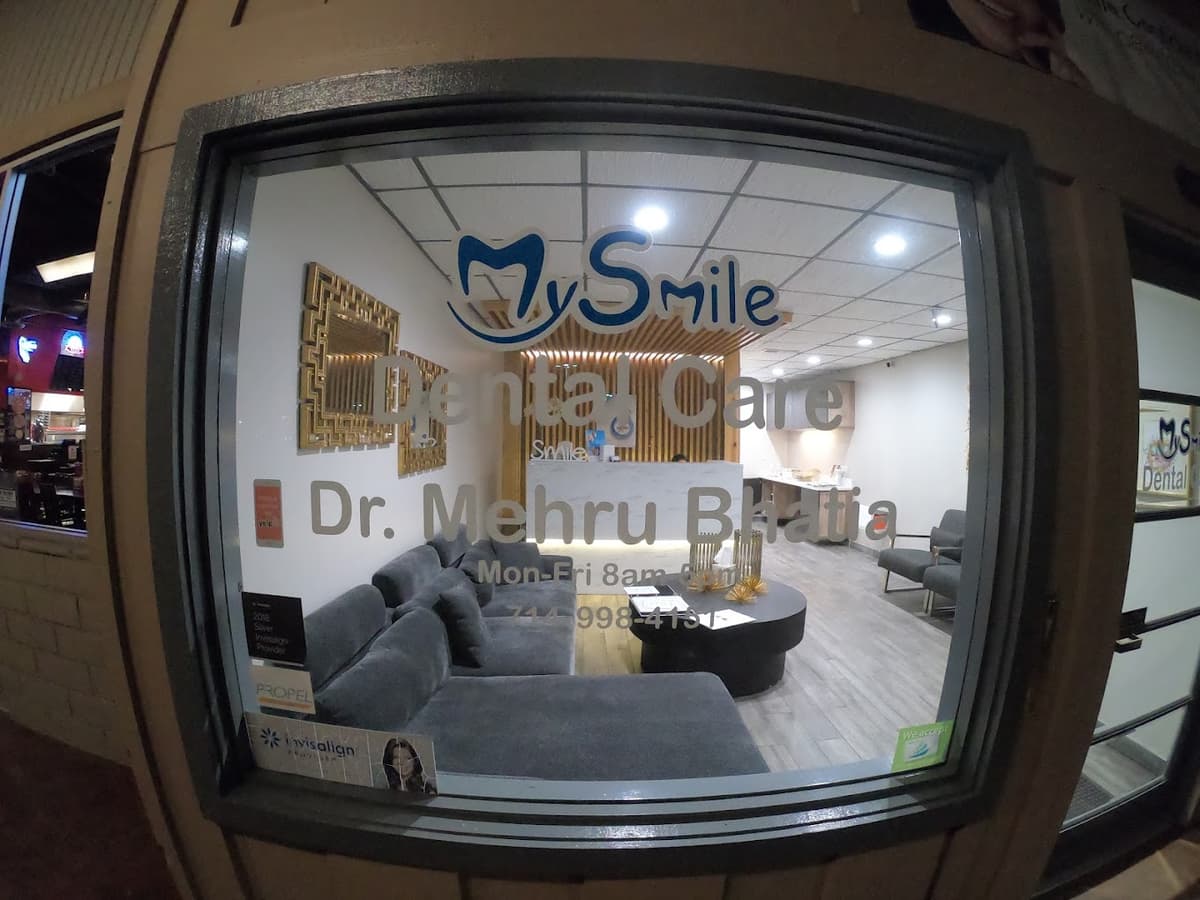 MySmile Dental Care storefront at night, showing the office entrance with Dr. Mehru Bhatia signage